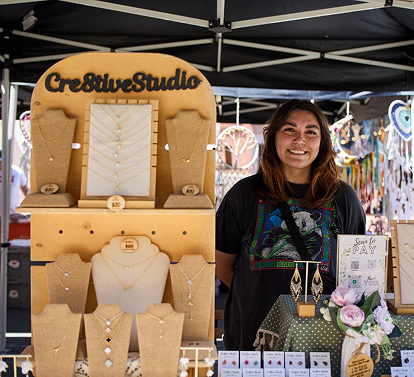 Artisan selling handmade jewelry at a creative market